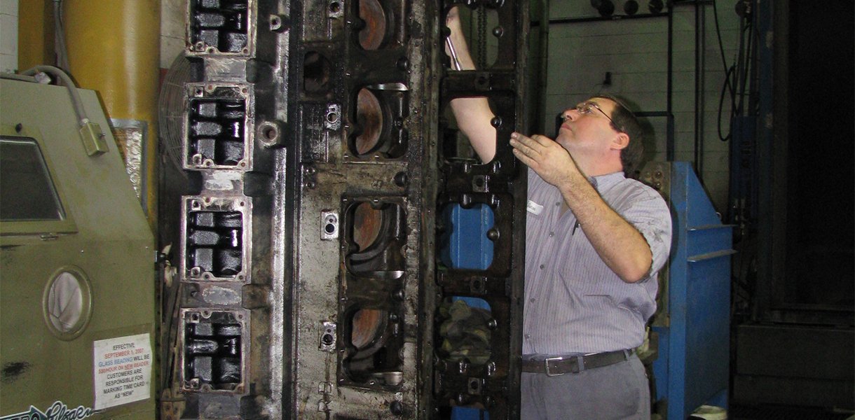 A Rutt's Machine, Inc. technician cleaning a disassembled engine